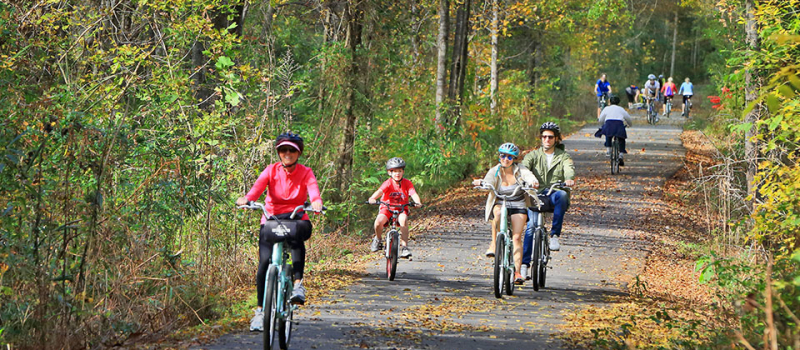 People enjoying riding on the trail in the fall